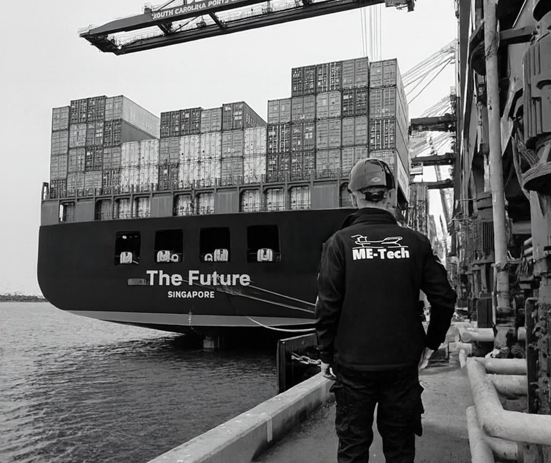 ME-Tech technician looking at a container ship at the quay